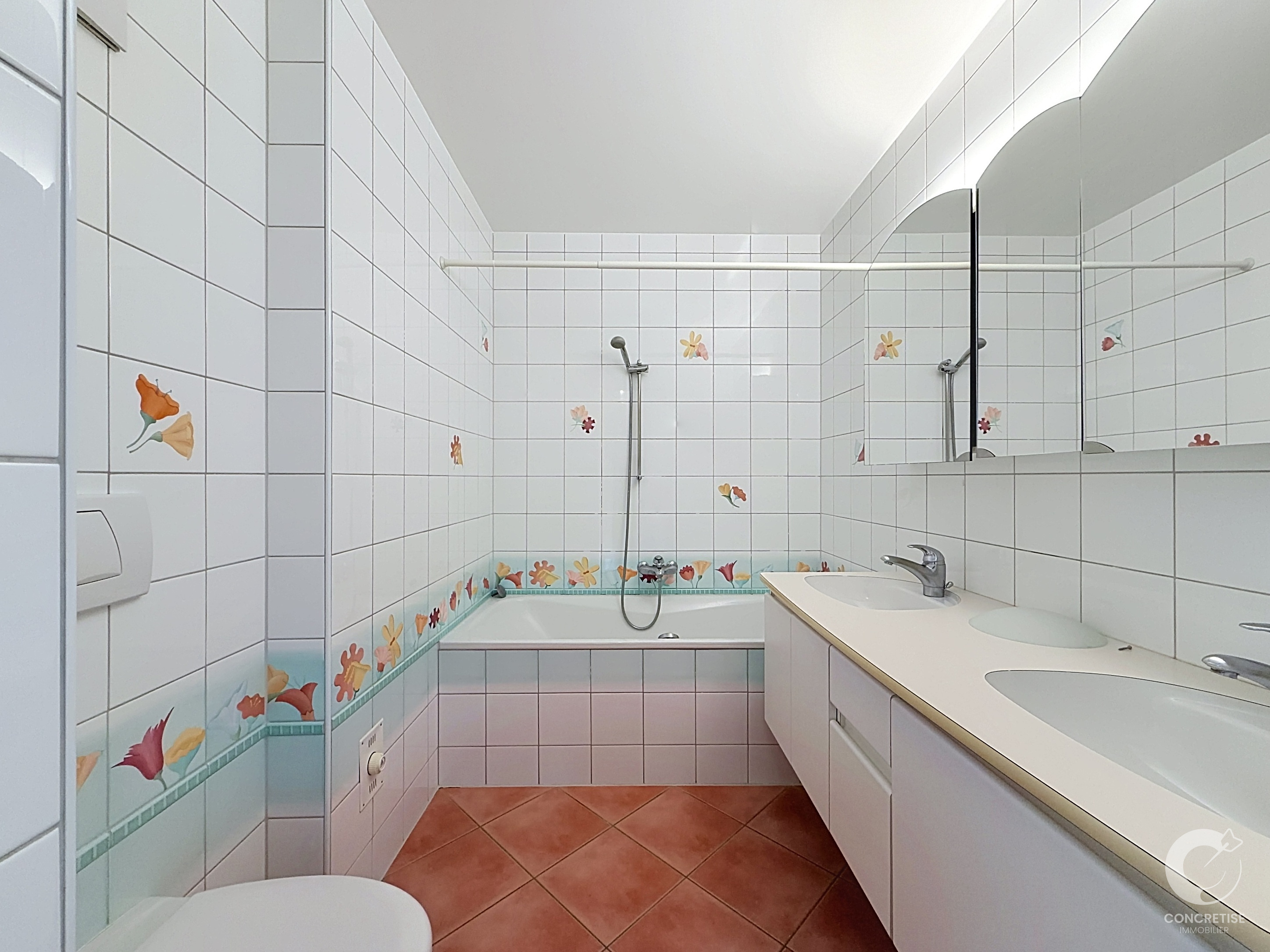 Badezimmer mit Badewanne und Doppelwaschtisch