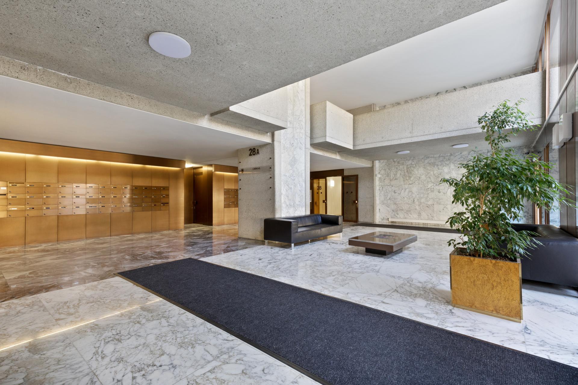 Elegantes Wohngebäude-Entrée mit Marmor, Postfächern und Sitzbereich