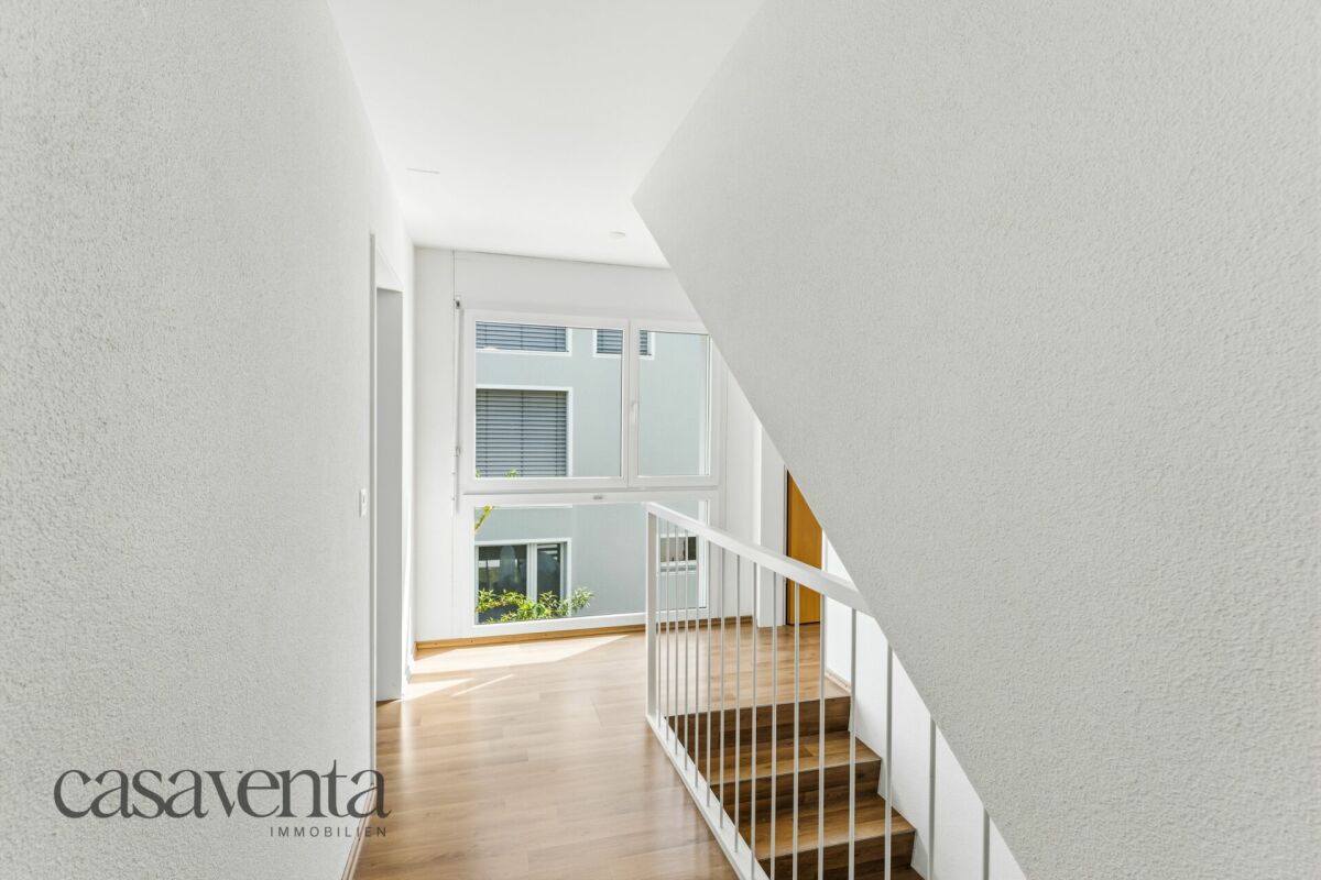 Heller Flur mit Treppe und großem Fenster