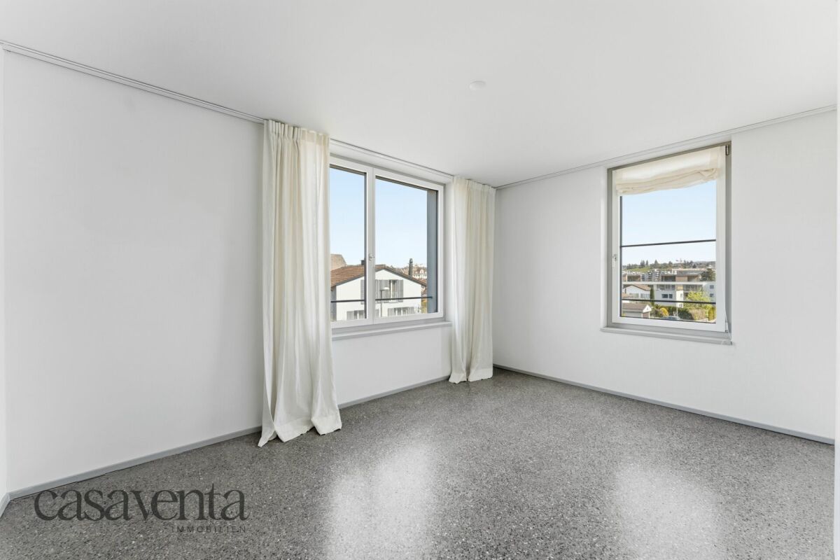 Helles, leeres Zimmer mit zwei Fenstern