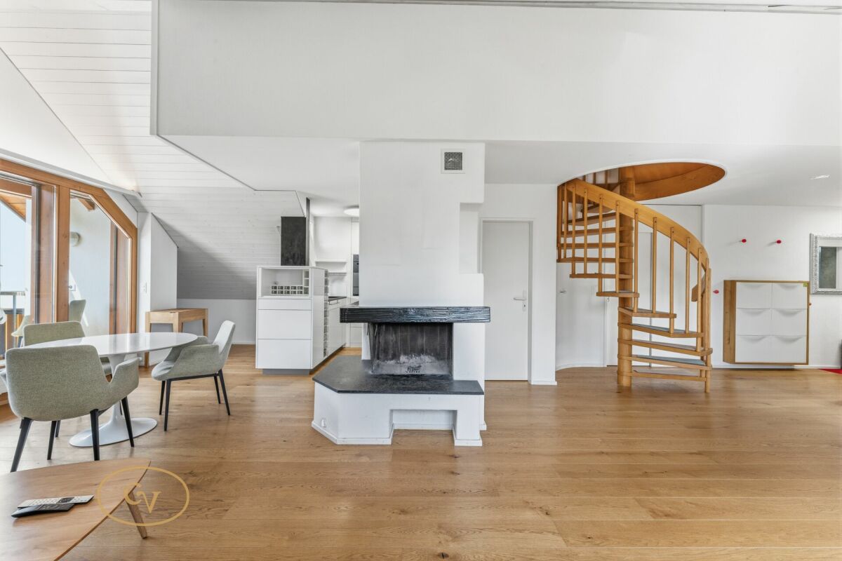 Offener Wohn- und Essbereich mit Wendeltreppe und Kamin