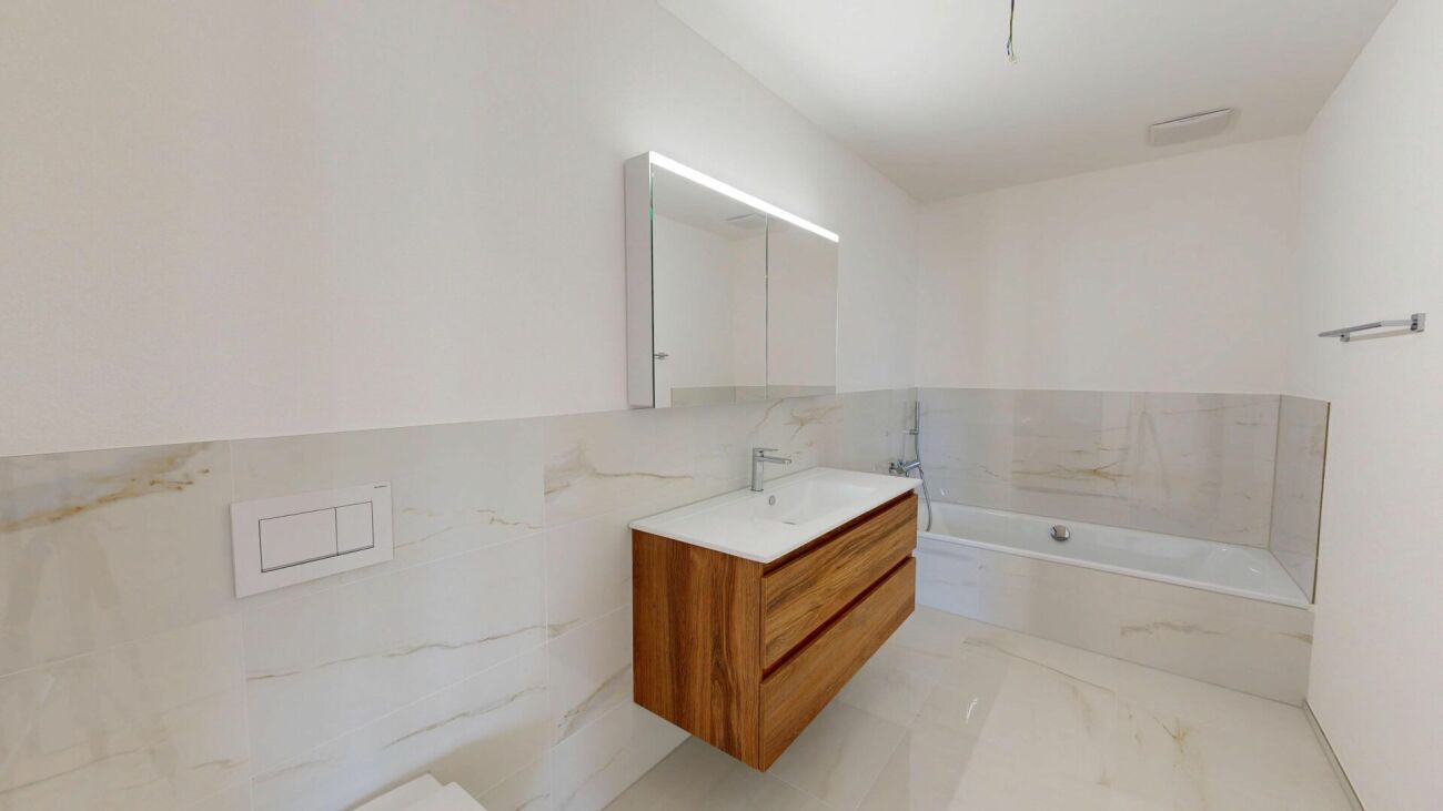 Modernes Badezimmer mit Wanne und Holzwaschtisch