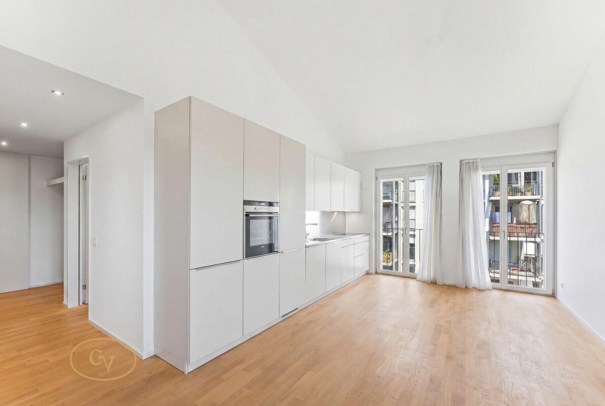 Offener Wohnraum mit Einbauküche und Balkonblick