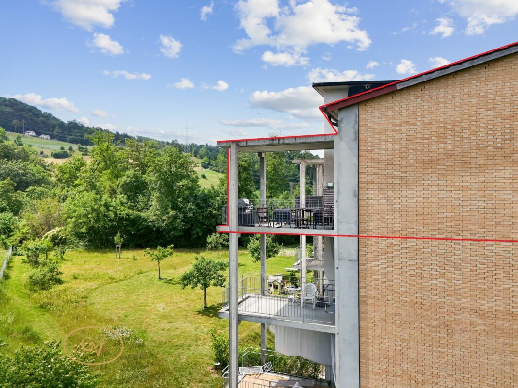 Außenansicht eines modernen Wohngebäudes mit Balkon und Grünblick
