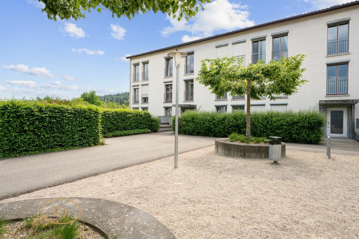Außenansicht eines Mehrfamilienhauses mit Hof- und Gartenbereich