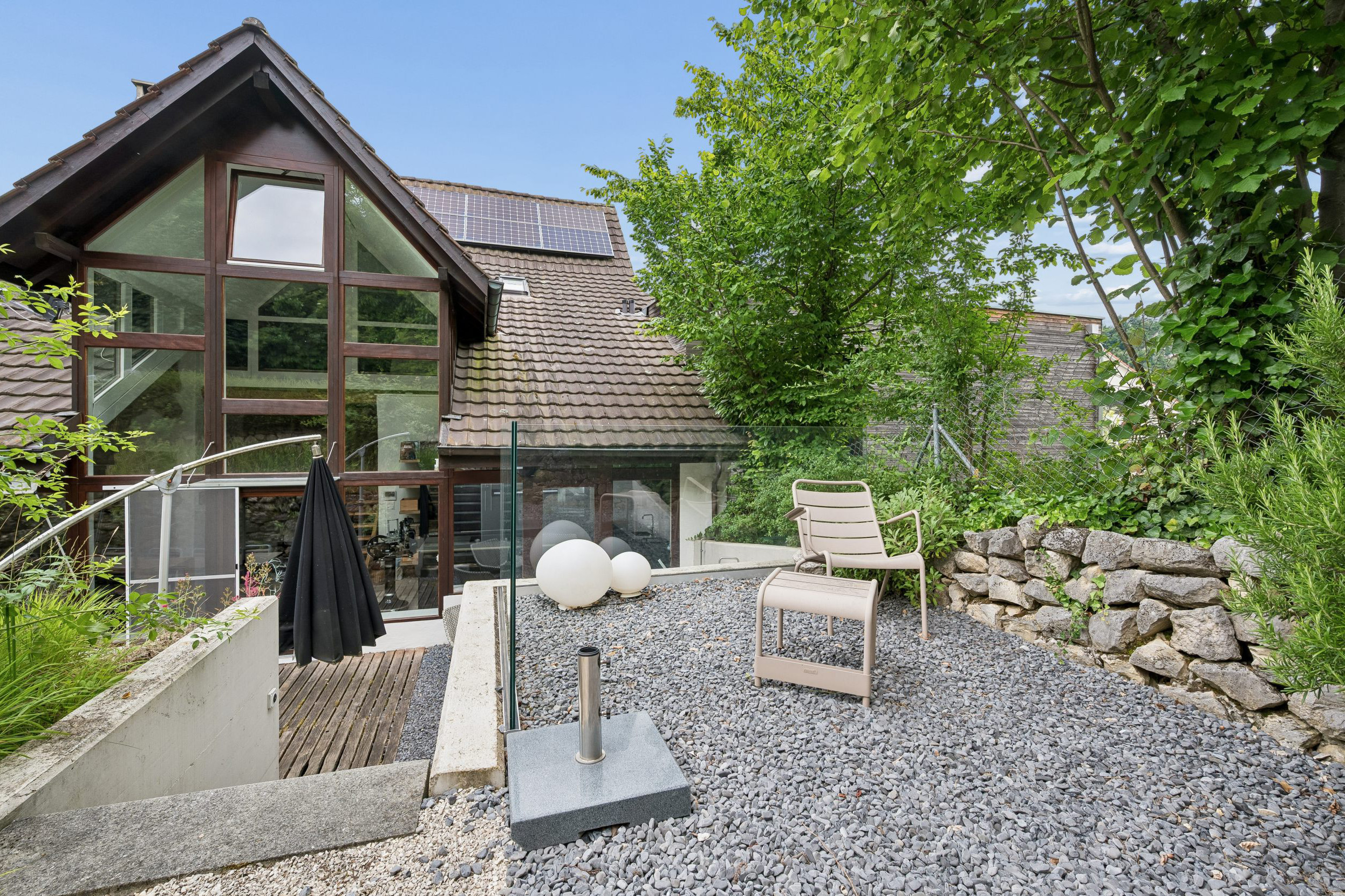 Außenansicht eines Hauses mit Garten und Dachterrasse