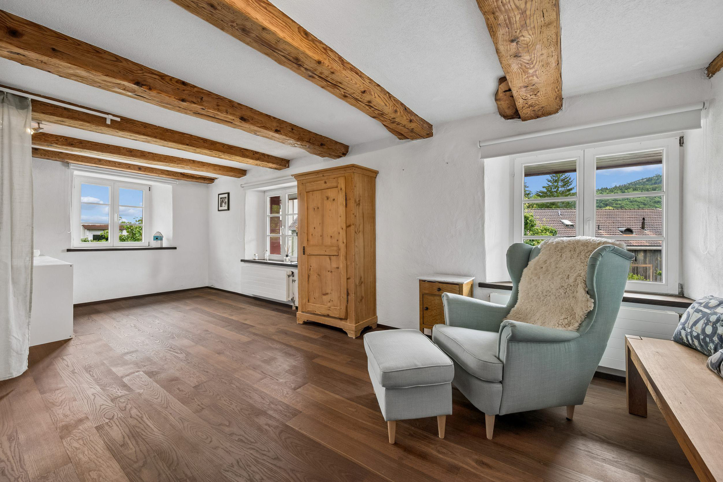 Helles Wohnzimmer mit sichtbaren Holzbalken