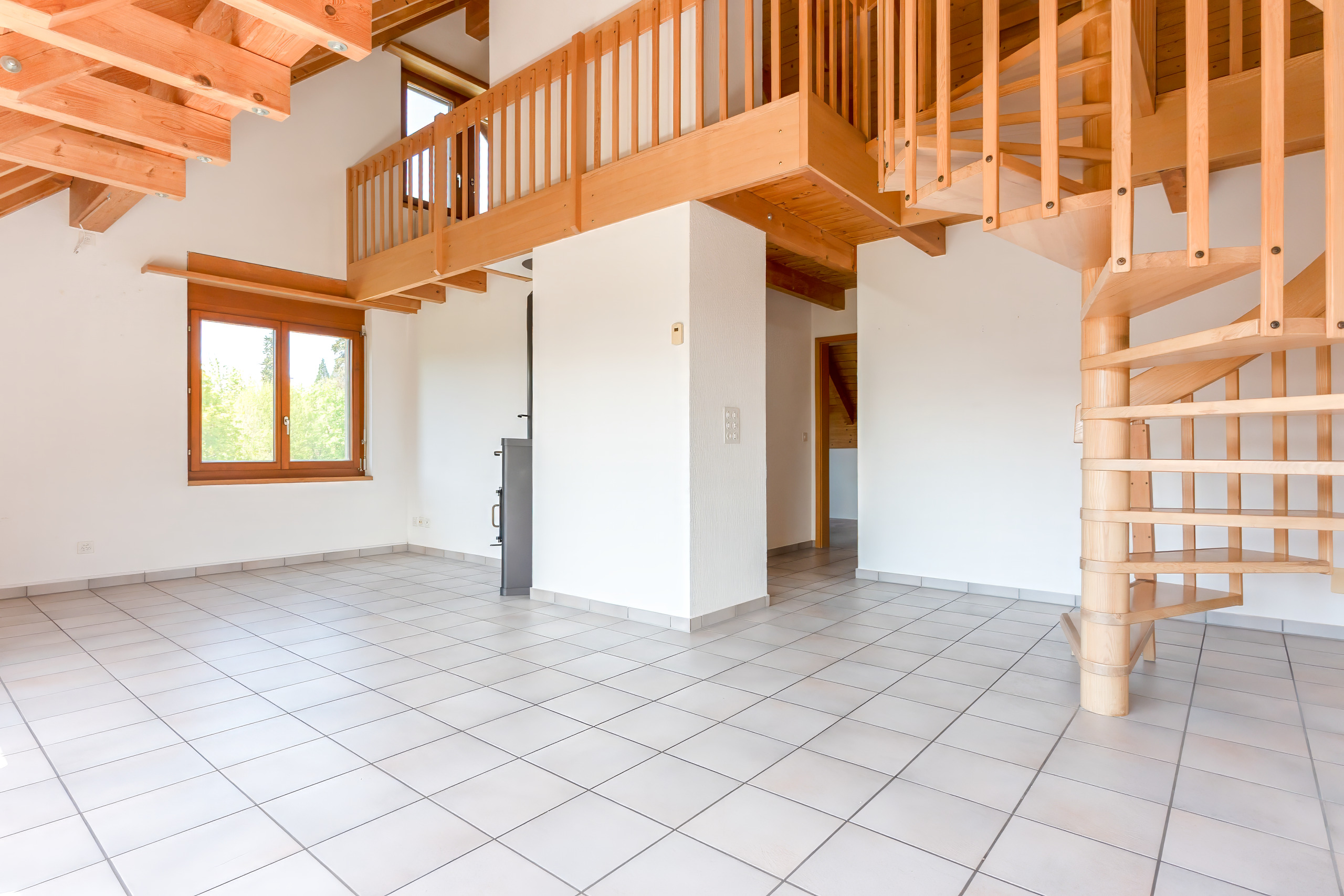 Heller Wohnraum mit Holztreppe und Galerie