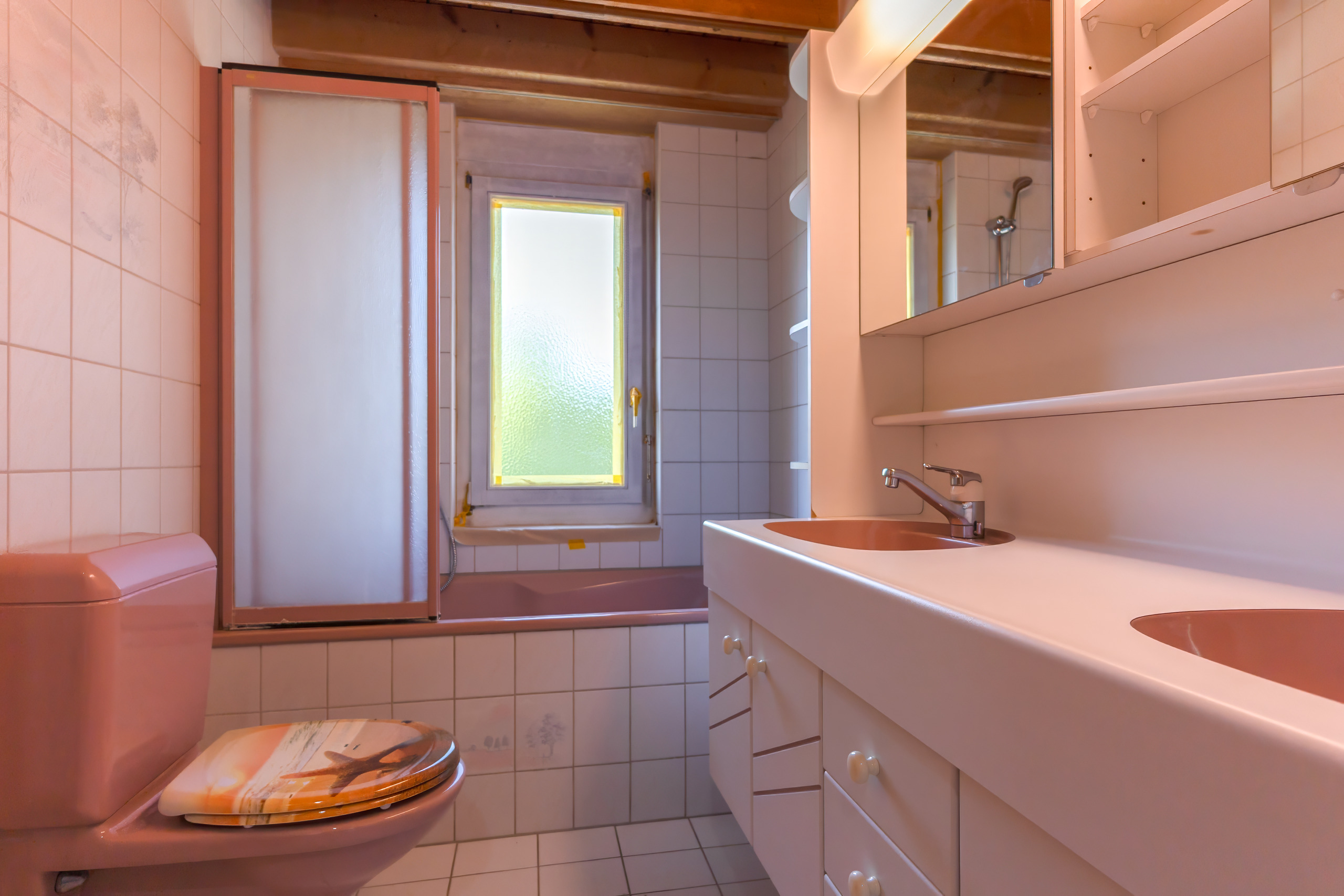 Kleines Badezimmer mit Badewanne und Waschtisch