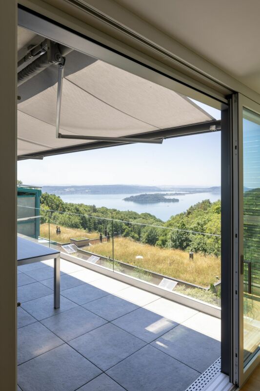 Blick von einer überdachten Terrasse auf einen See mit Inseln