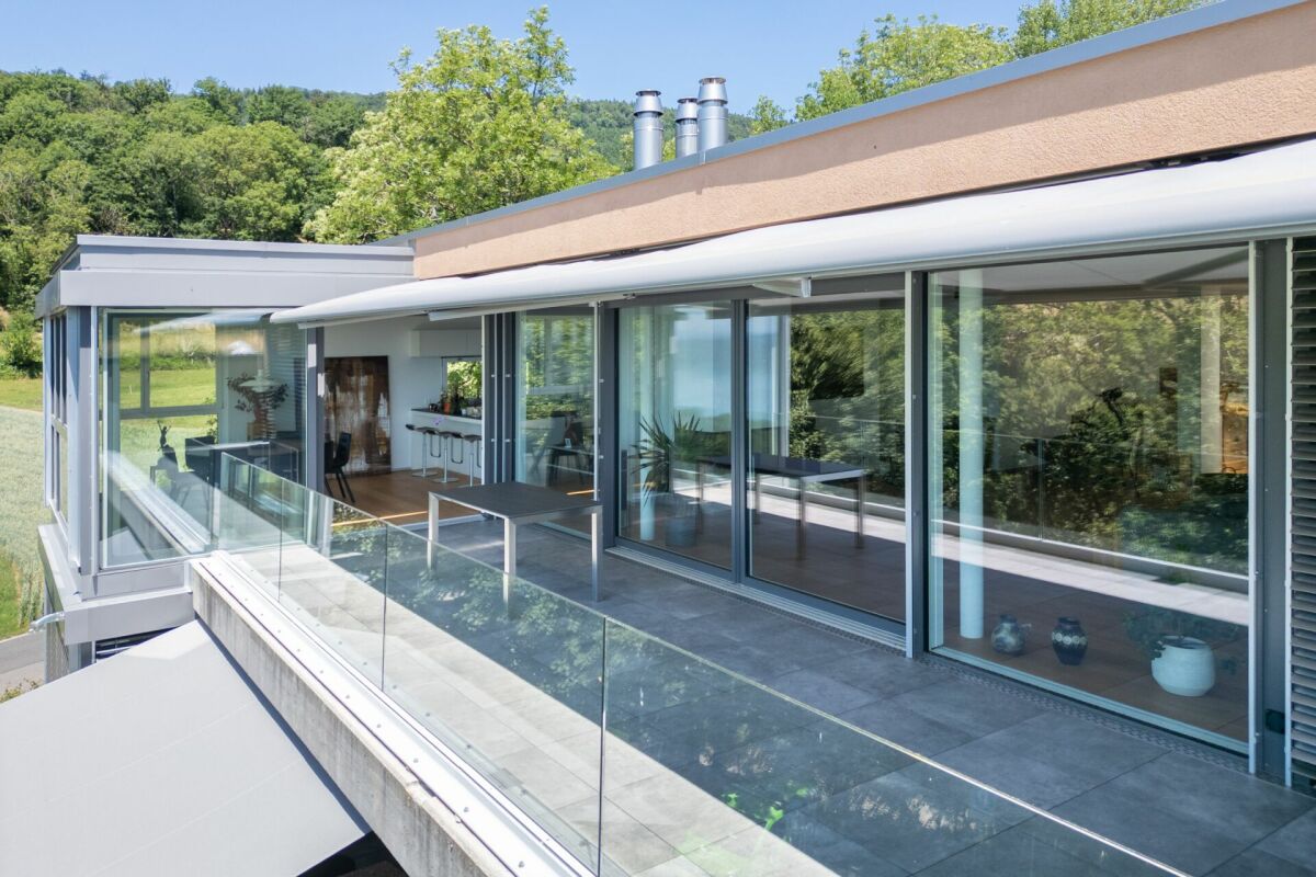 Modernes Haus mit großer Glasfassade und Balkon