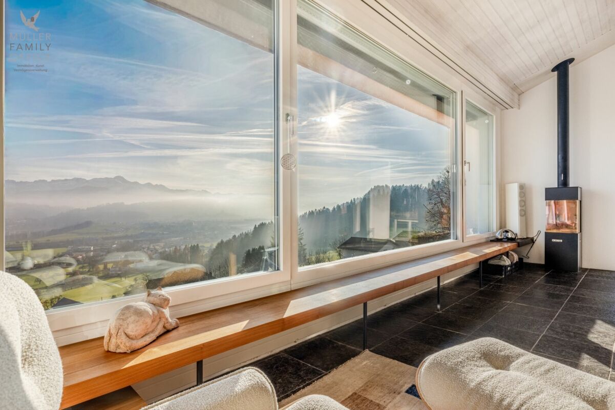 Wohnraum mit Panoramafenstern und Kaminofen