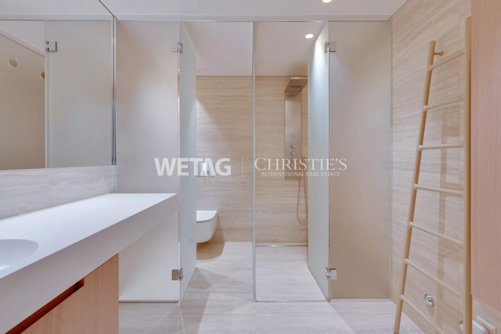 Modernes Badezimmer mit Glasdusche und Holzleiter
