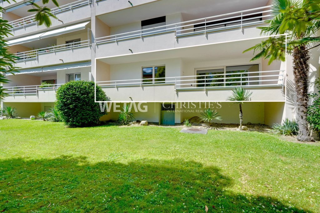 Außenansicht eines modernen Wohngebäudes mit Balkon und Rasenfläche