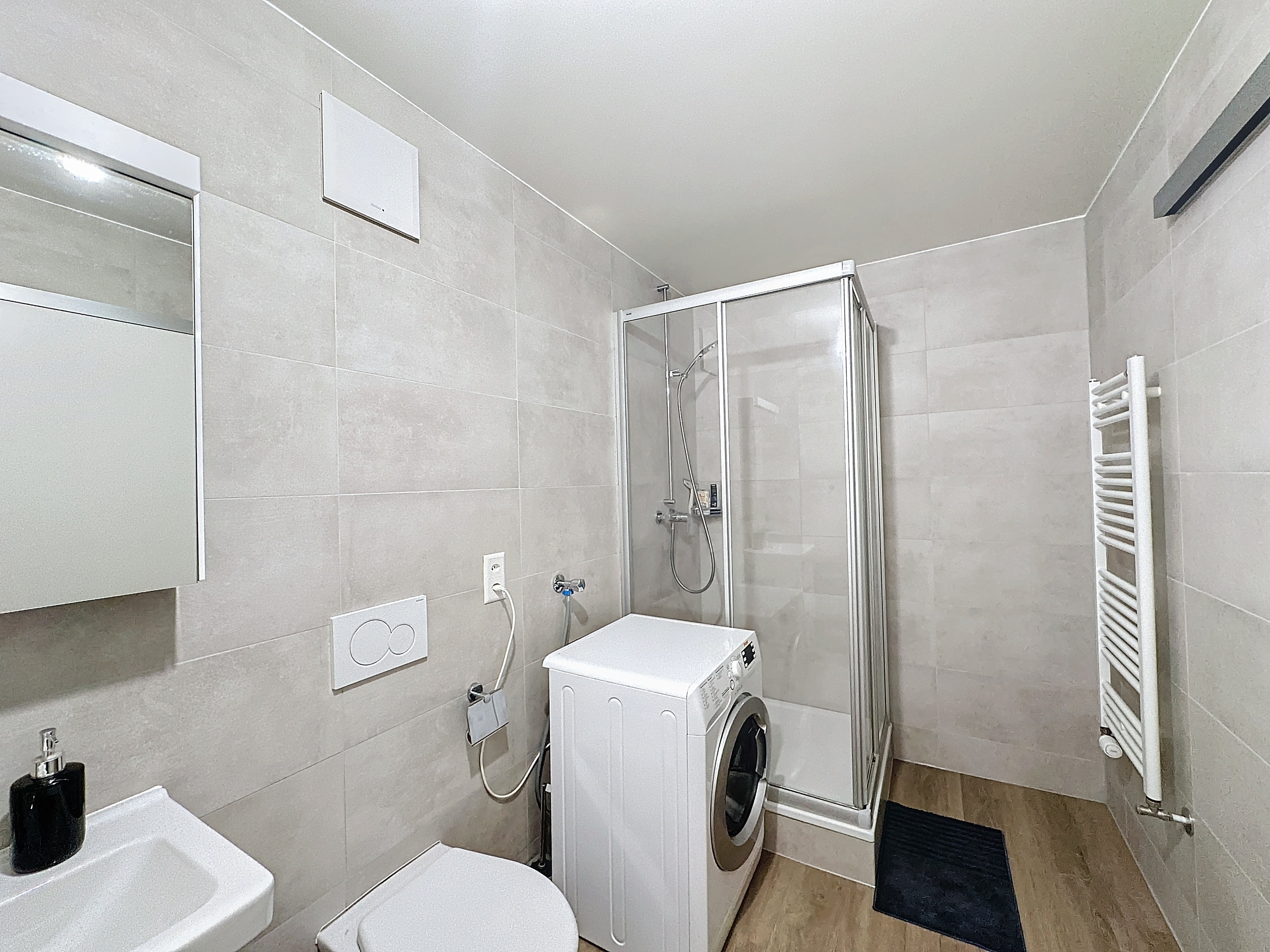 Modernes Badezimmer mit Dusche und Waschmaschine