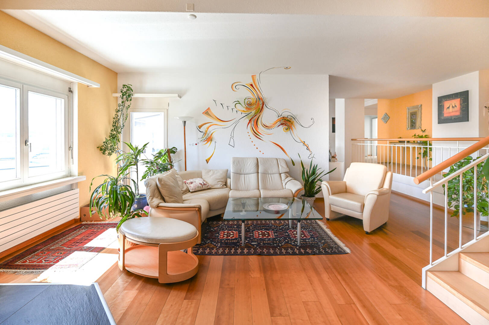 Helles Wohnzimmer mit Treppe und Balkonblick