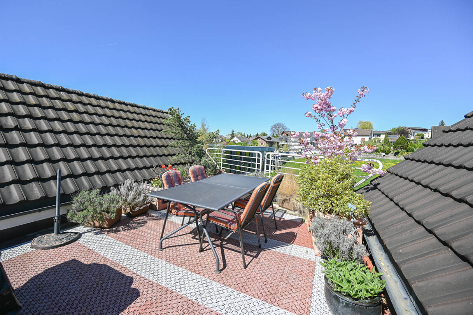 Dachterrasse mit Sitzgruppe und Blick ins Wohnviertel