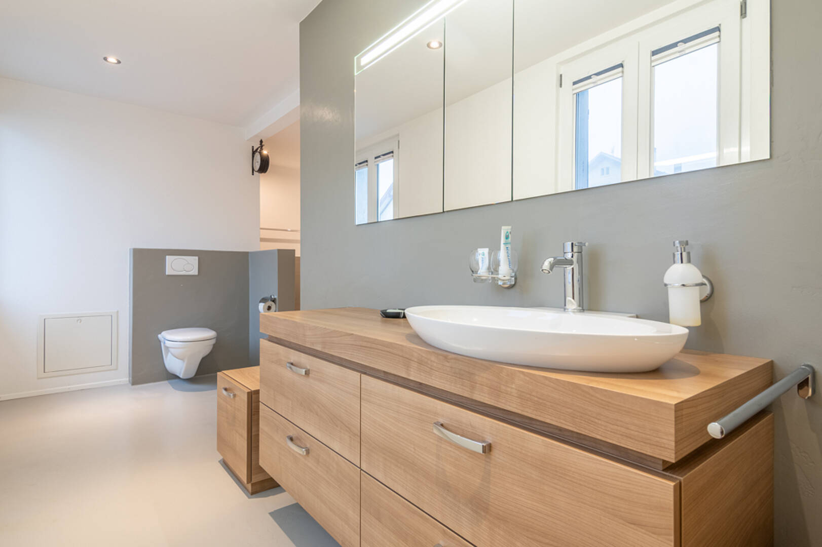 Modernes Badezimmer mit Holzwaschtisch und Spiegel