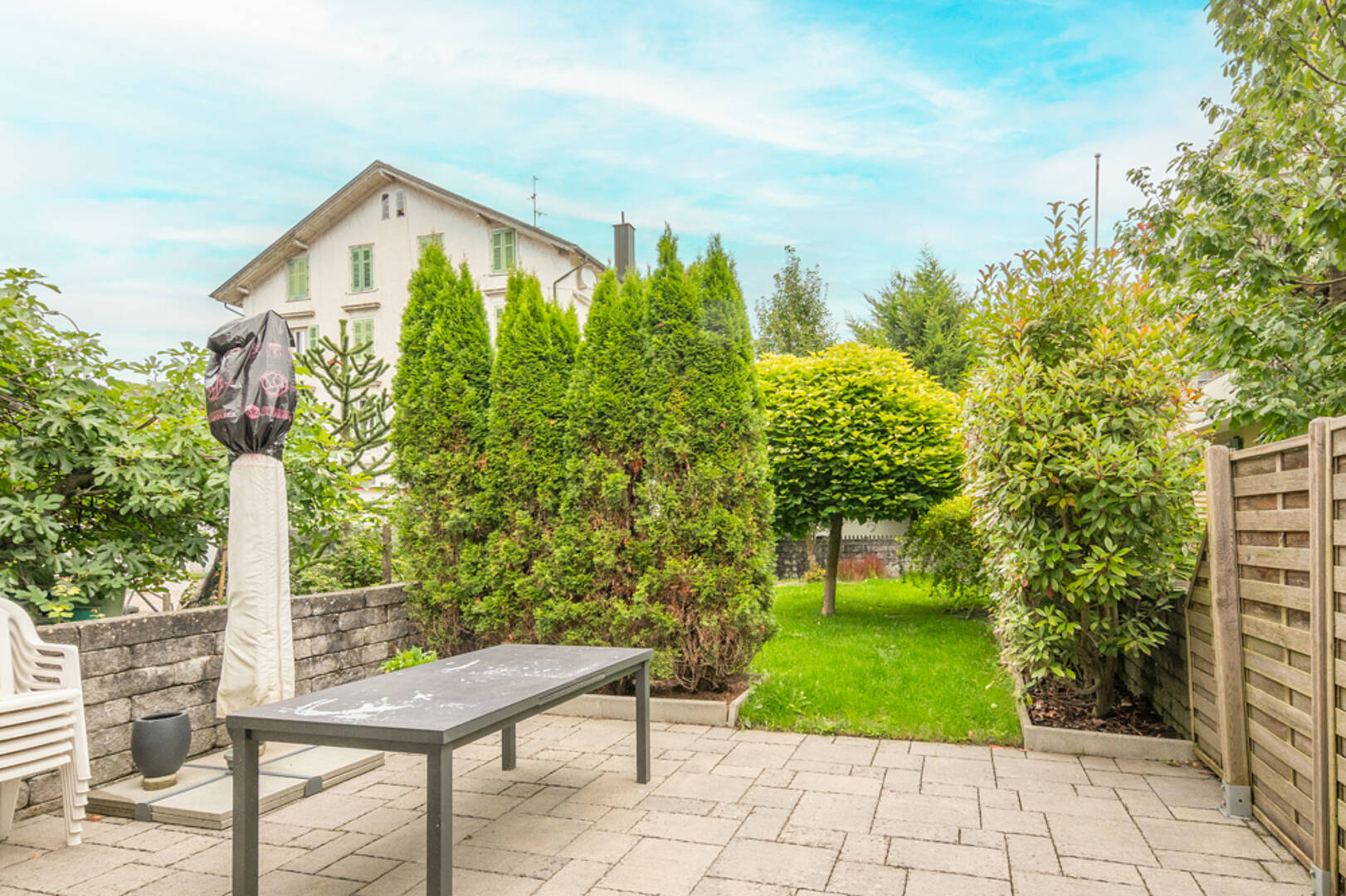 Garten und Terrasse mit Blick auf ein Wohnhaus