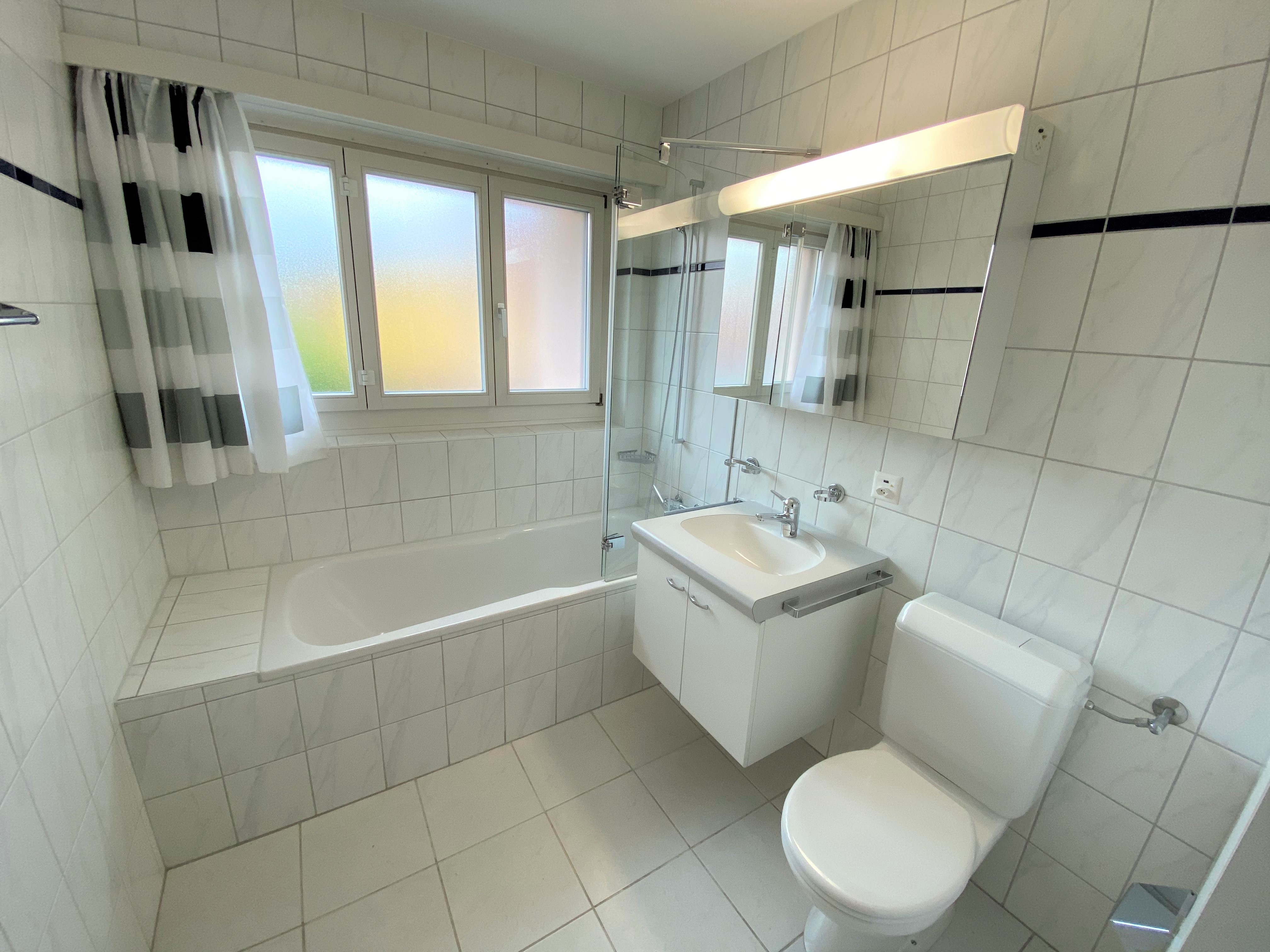 Helles Badezimmer mit Badewanne, WC und Waschtisch