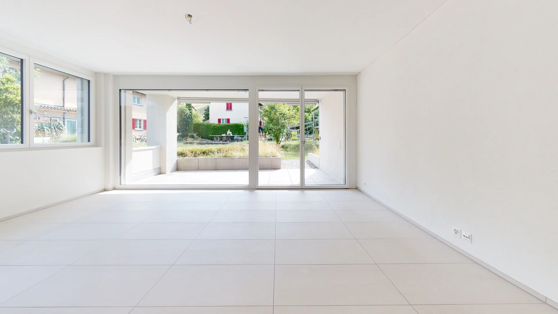 Heller leerer Wohnraum mit großflächigen Fensterfronten