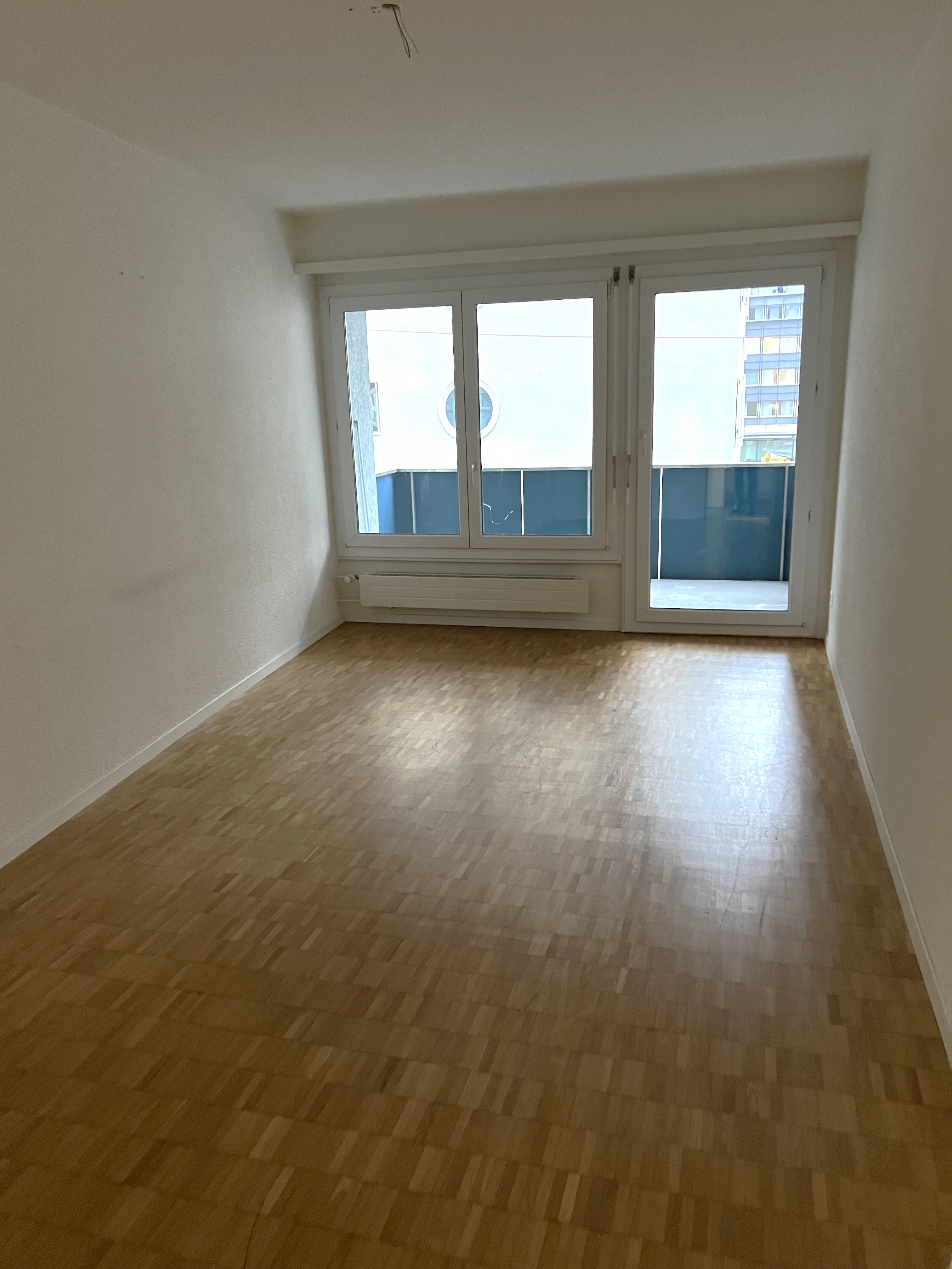 Leerer Wohnraum mit Balkon und Tageslicht
