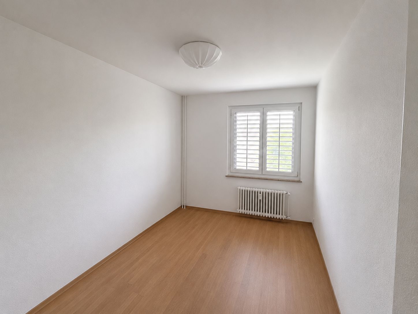 Heller leerer Raum mit Fenster und Heizkörper