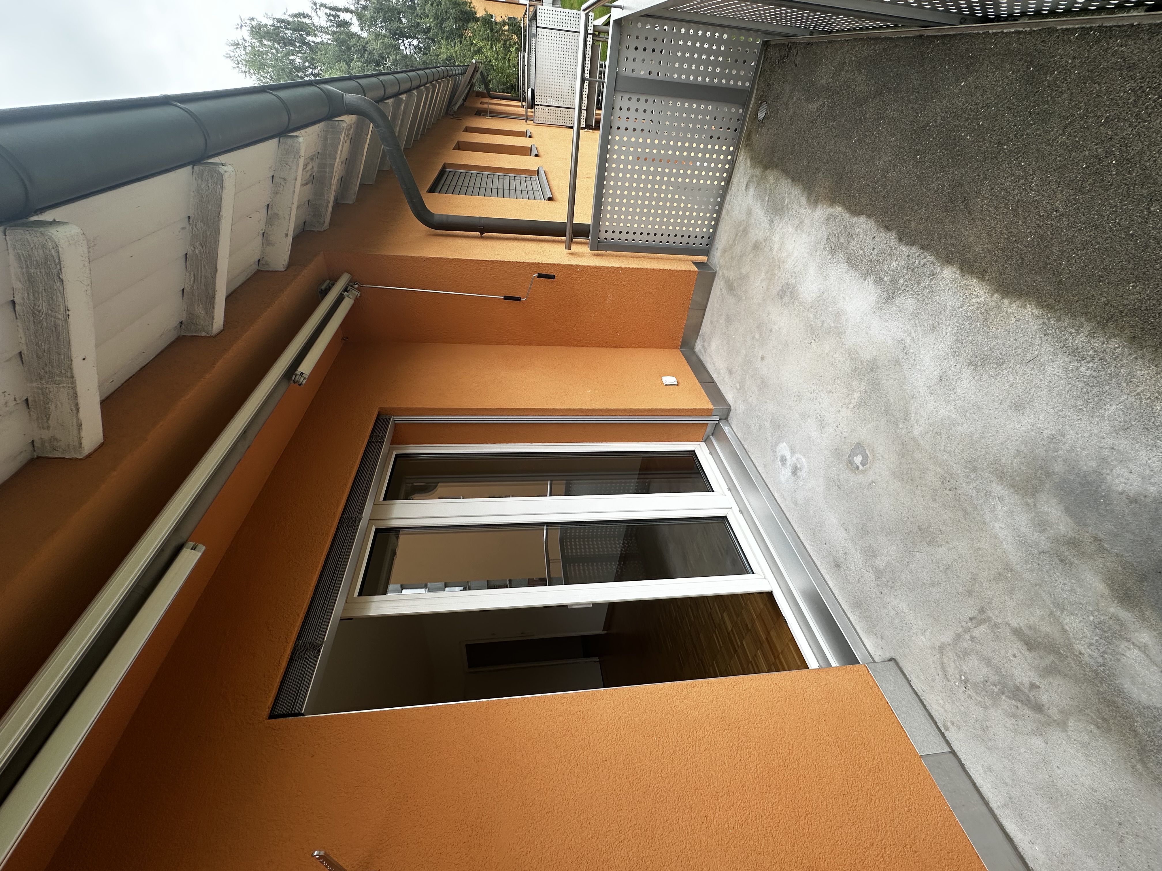 Balkon mit orangefarbener Fassade