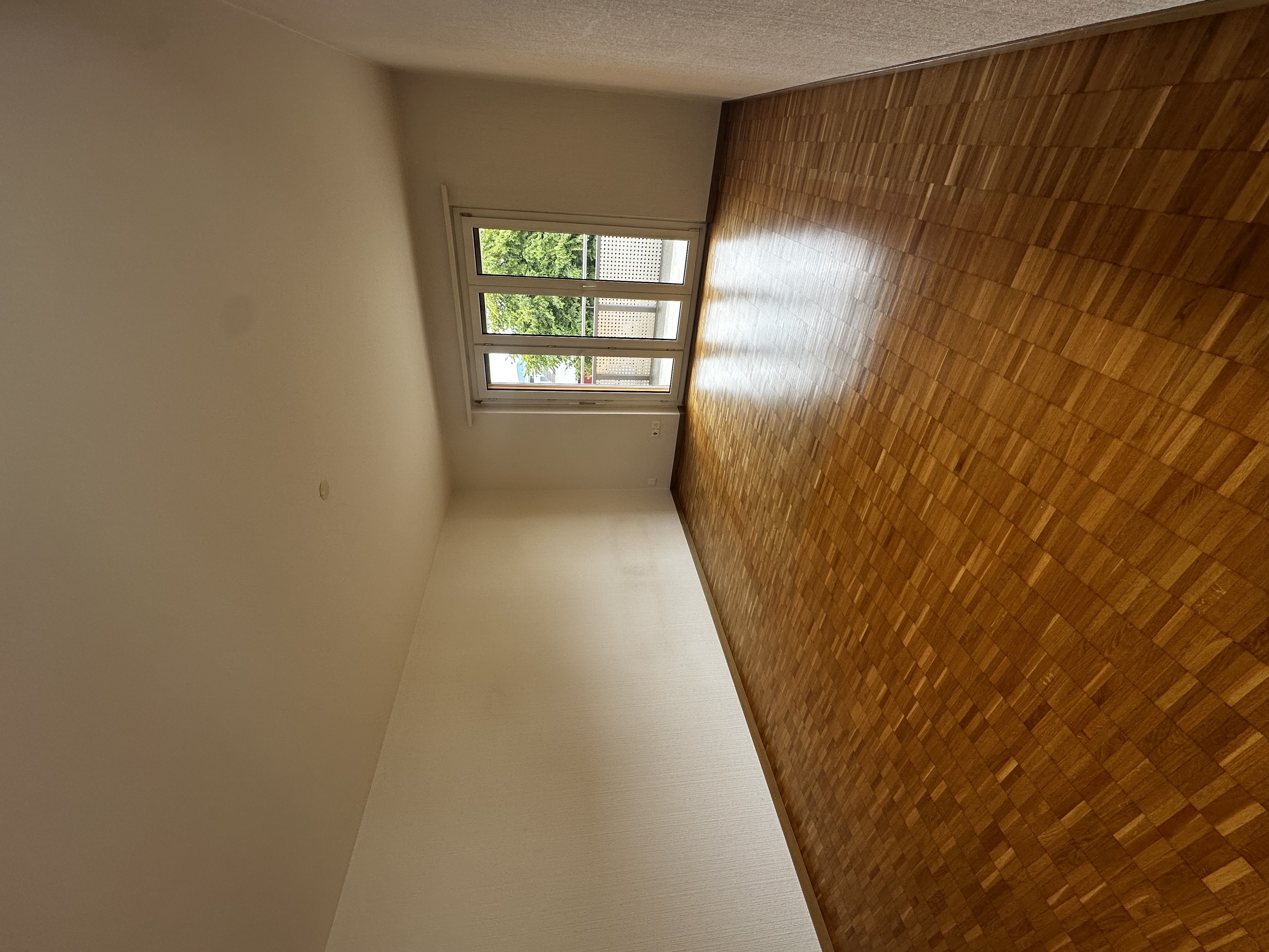 Leerer Wohnraum mit Balkonzugang