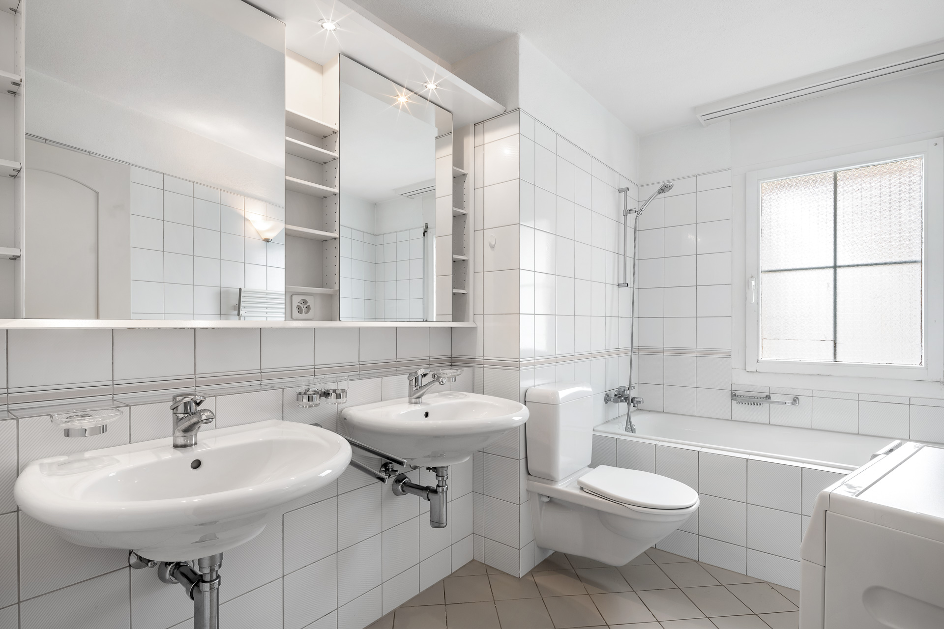 Helles Badezimmer mit Doppelwaschbecken und Badewanne