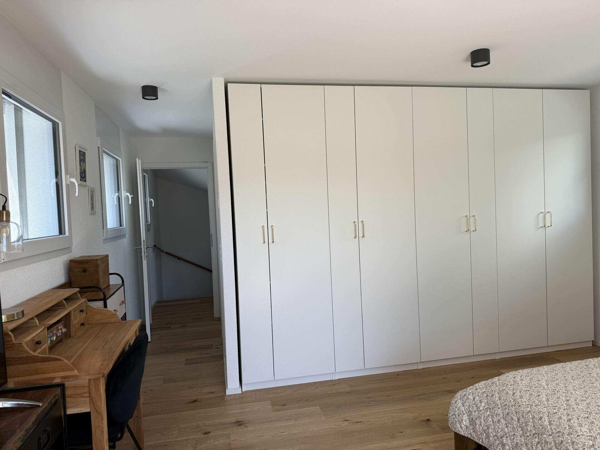 Helles Schlafzimmer mit Einbauschrank und Holzschreibtisch