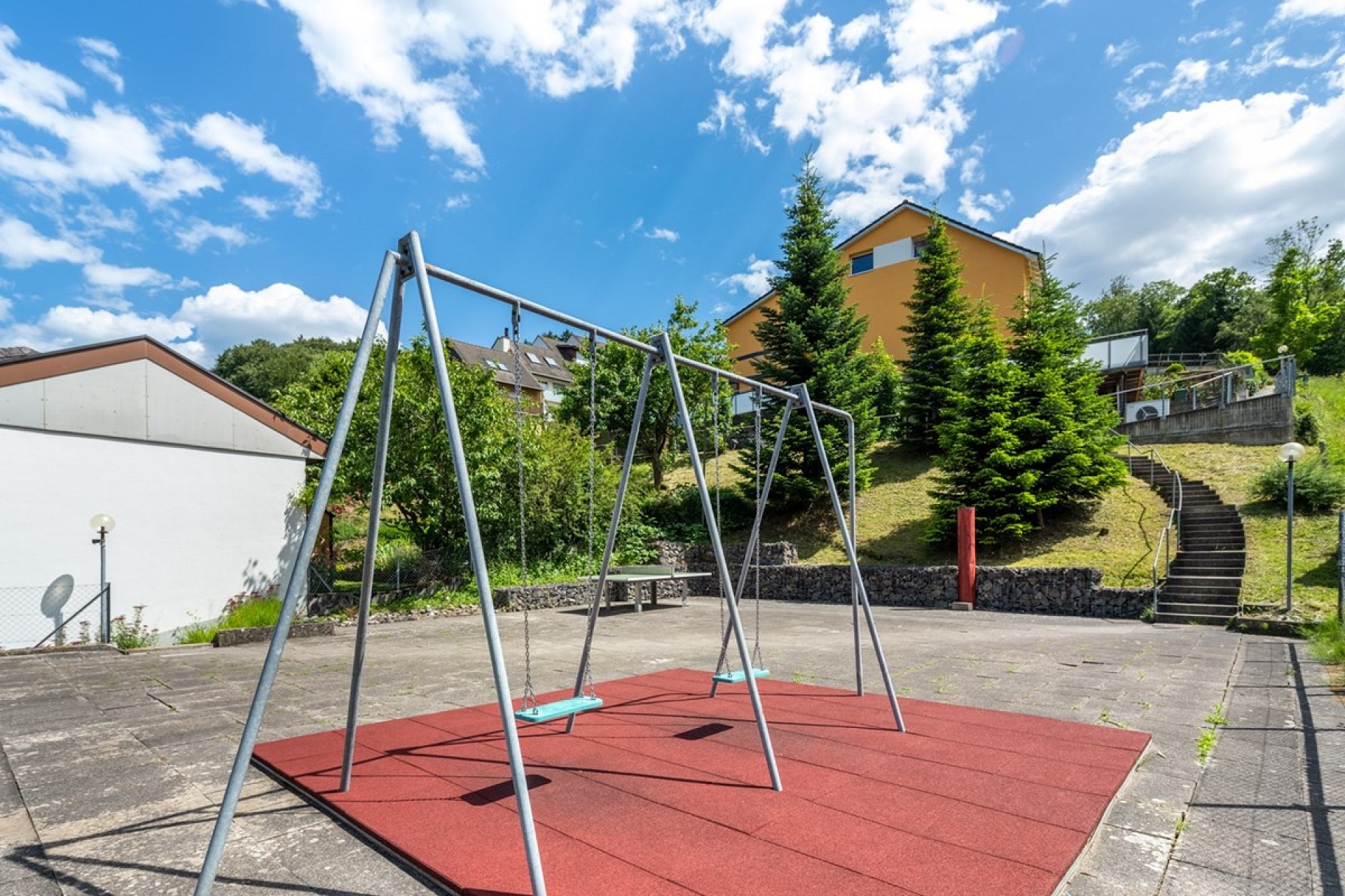 Außenbereich mit Spielplatz und Hanglage