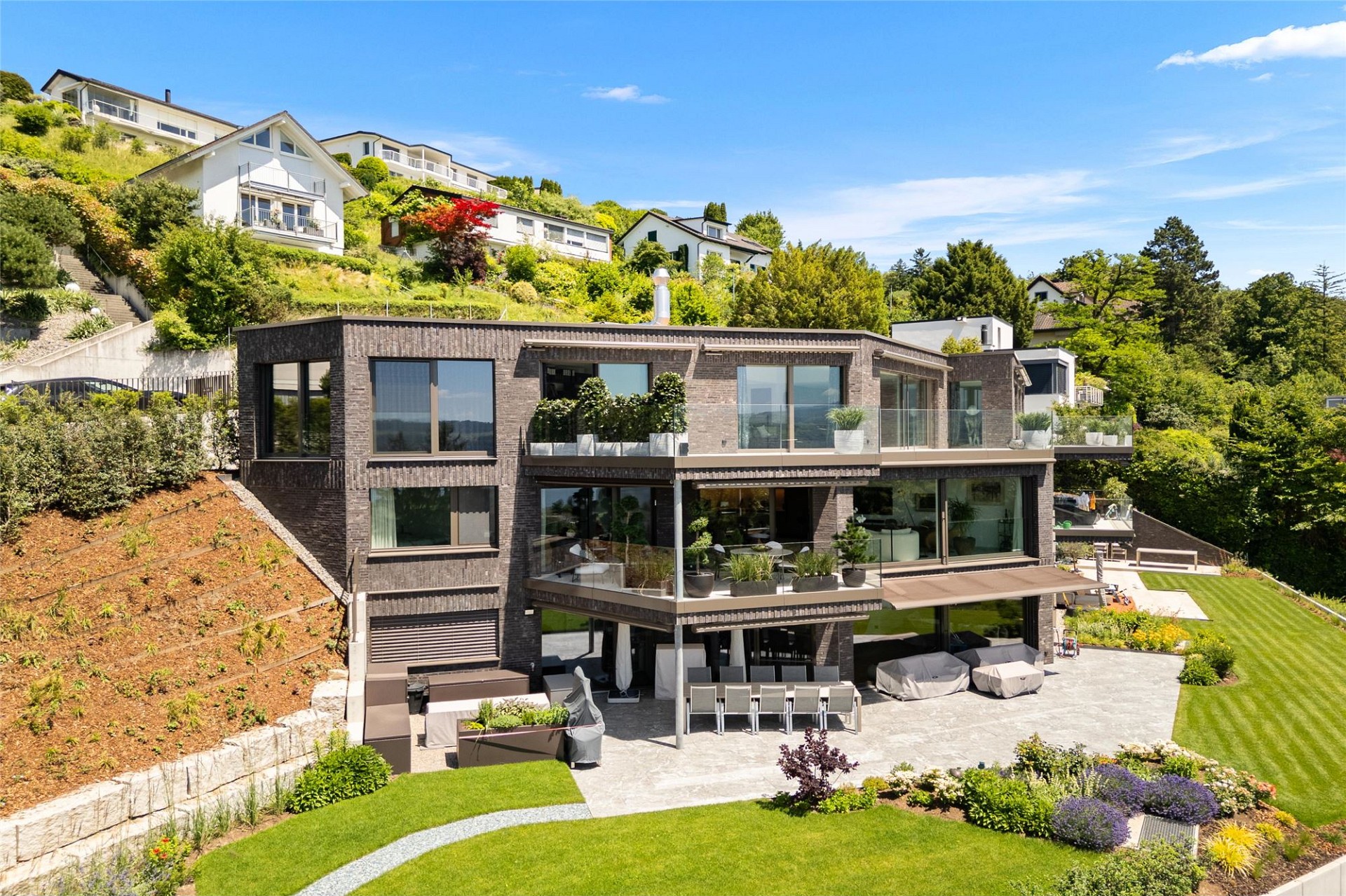 Moderne Hangvilla mit Garten und Terrassen