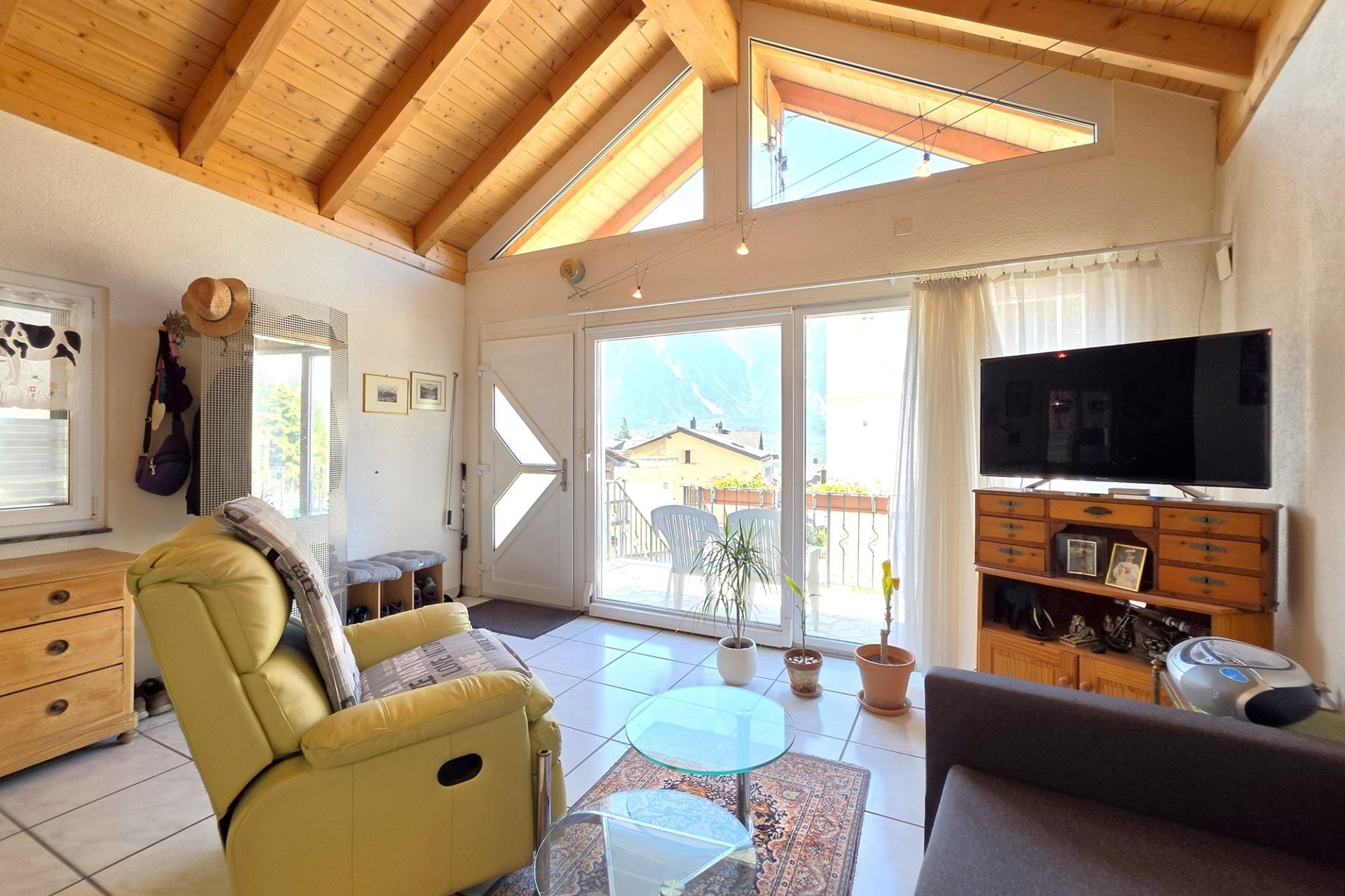 Helles Wohnzimmer mit Holzdecke und Terrassentür