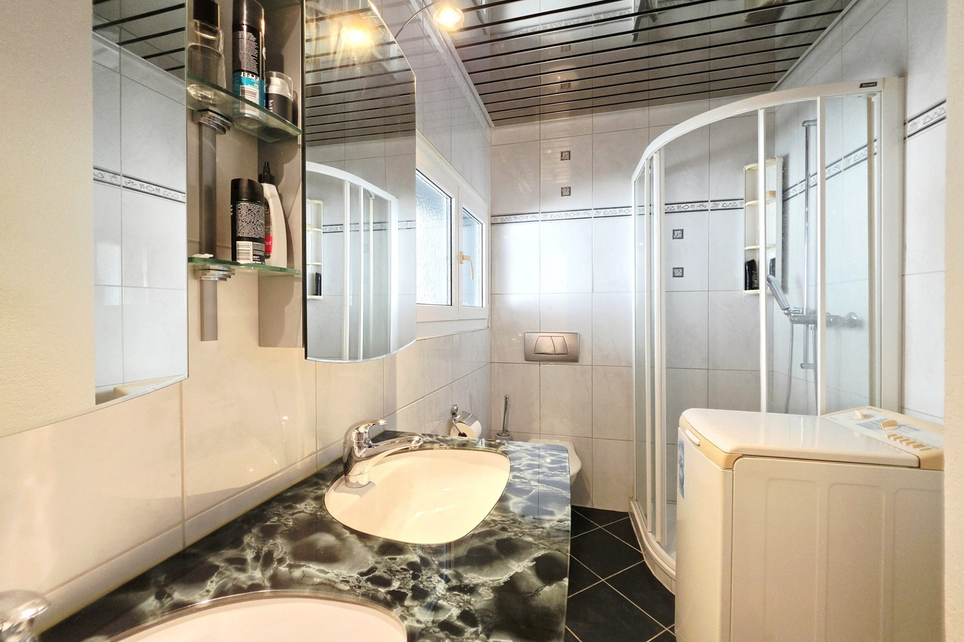 Kleines Badezimmer mit Dusche und Waschtisch
