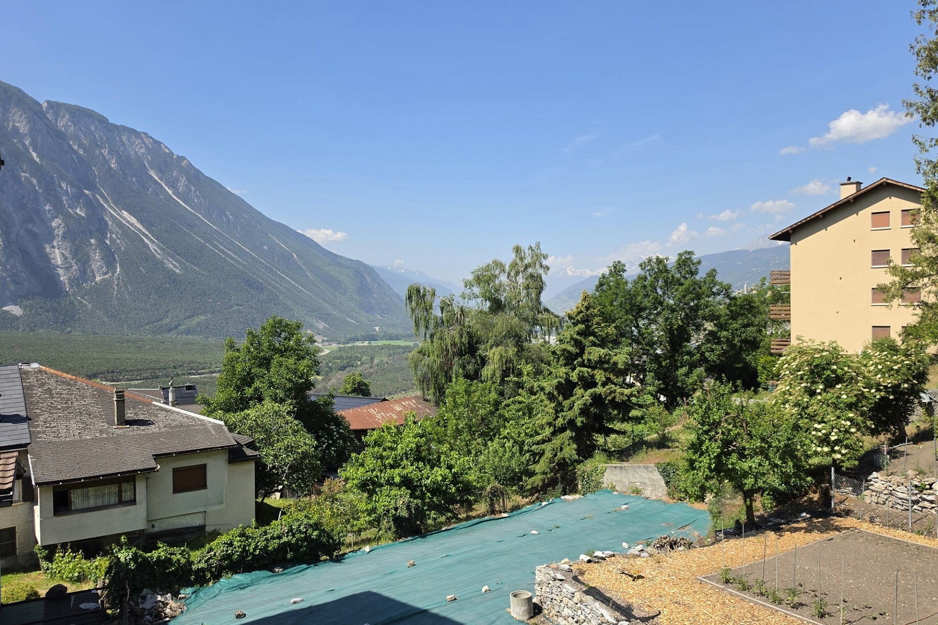 Alpenblick über Wohnhäuser und Garten