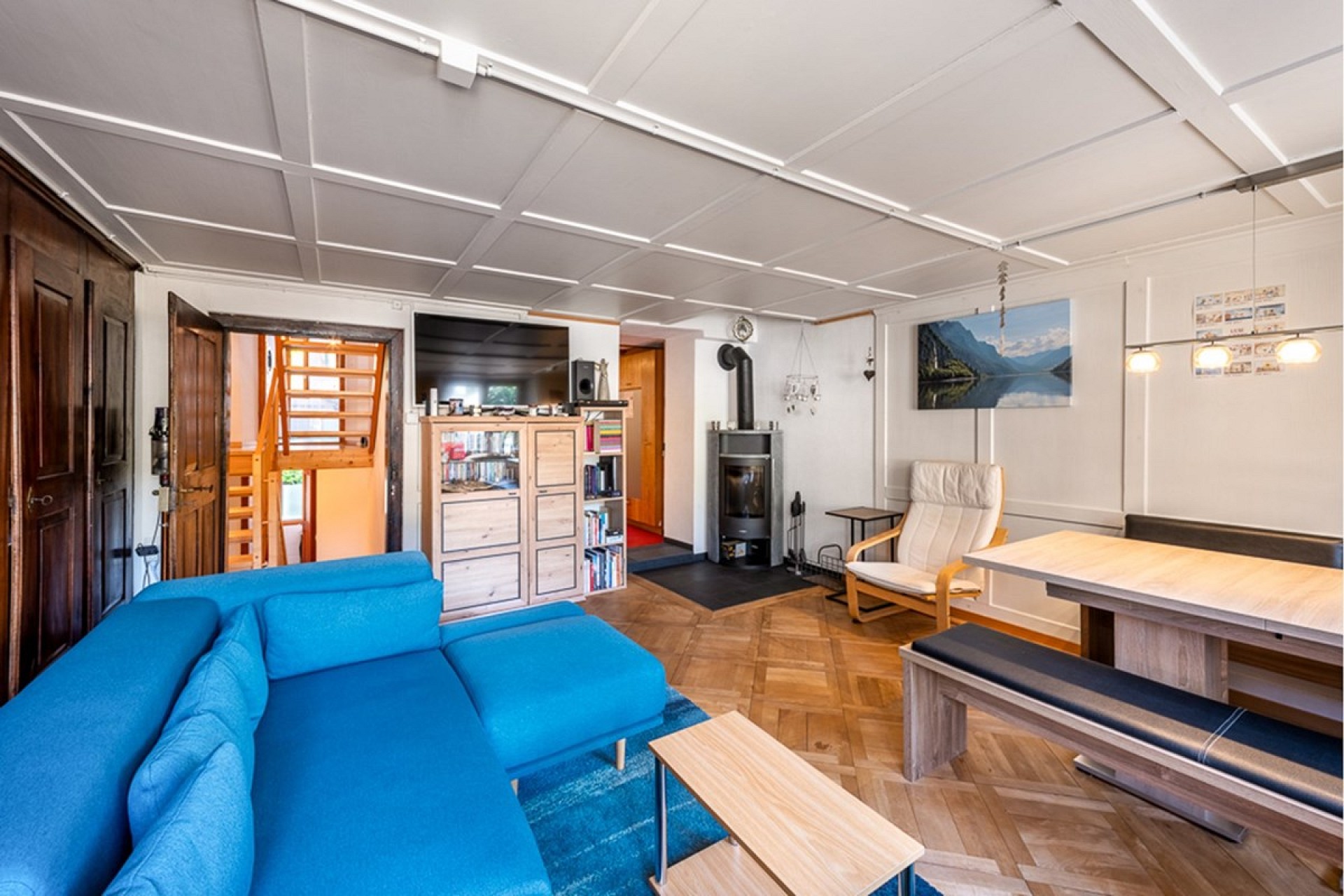 Wohnzimmer mit Kamin und blauem Sofa