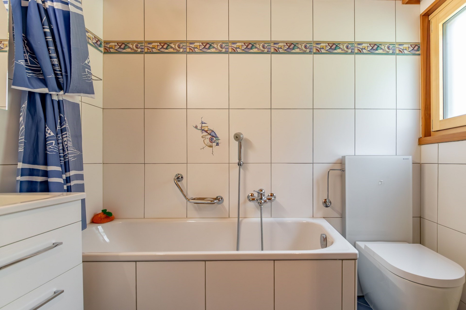 Badezimmer mit Wanne, WC und Fenster