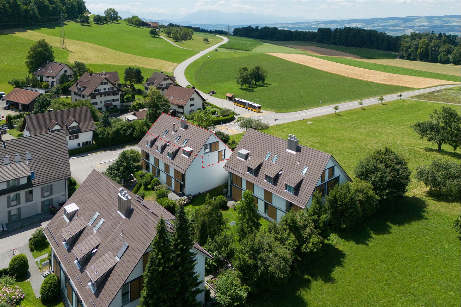 Luftaufnahme eines Wohngebiets in grüner Hügellandschaft