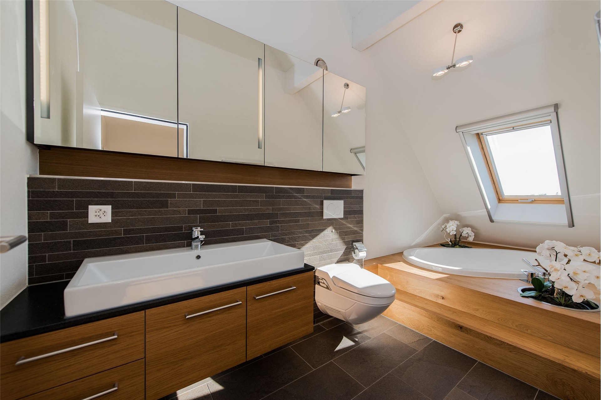 Modernes Badezimmer mit Dachfenster, Waschtisch und Badewanne