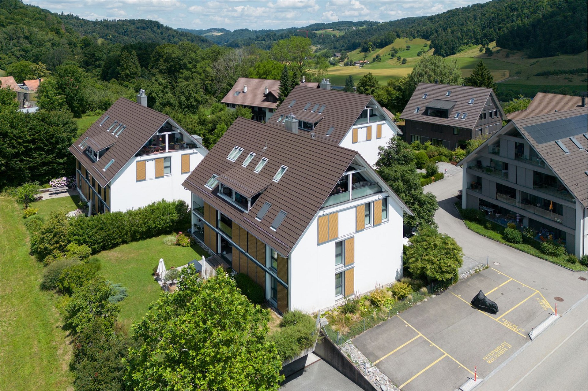 Luftaufnahme einer Wohnsiedlung in grüner Hanglage