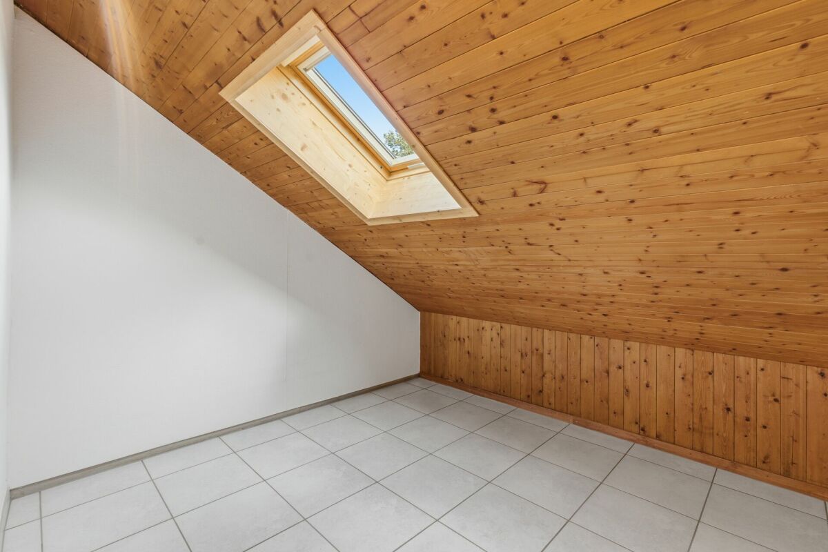 Dachgeschosszimmer mit Holzdecke und Dachfenster
