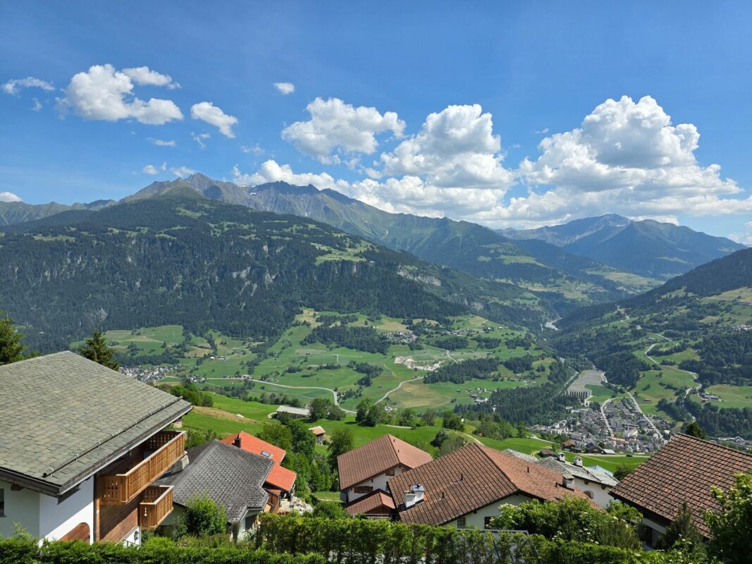 Alpenpanorama mit Bergtal und Häusern im Vordergrund