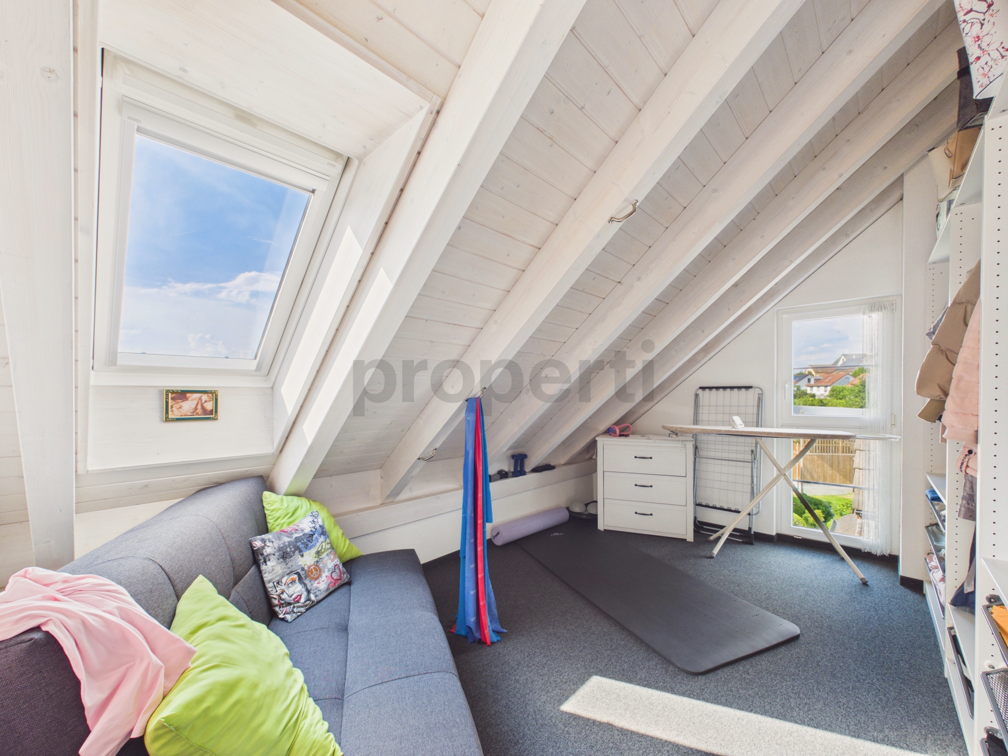 Dachgeschosszimmer mit Arbeitsplatz und Sofa