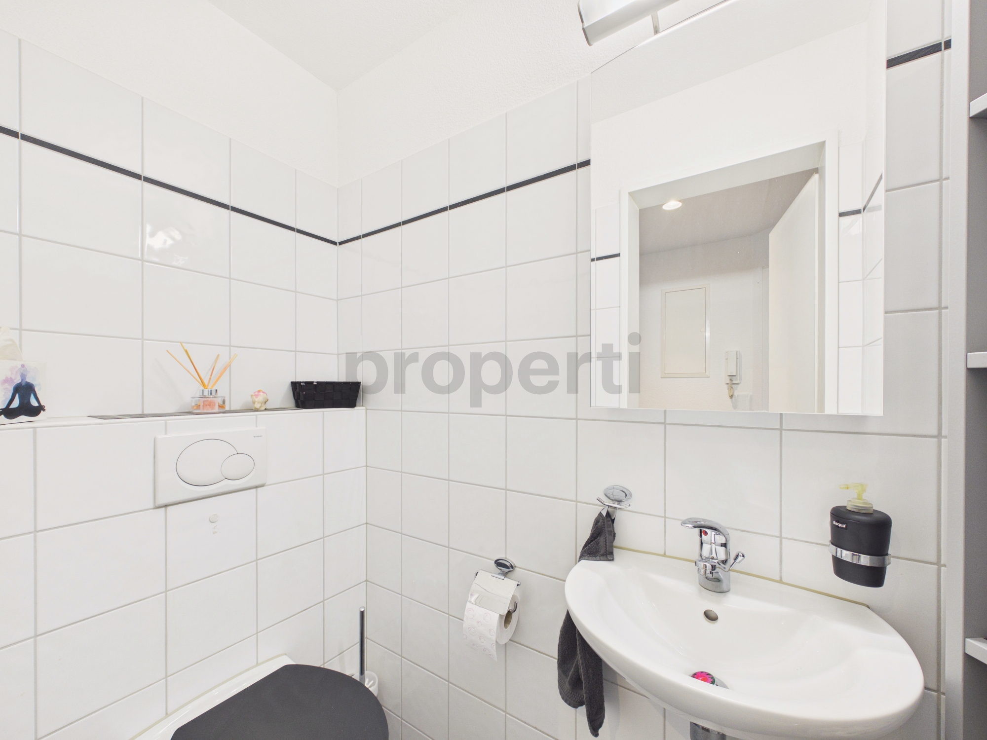 Kompaktes Gäste-WC mit weiß gefliesten Wänden