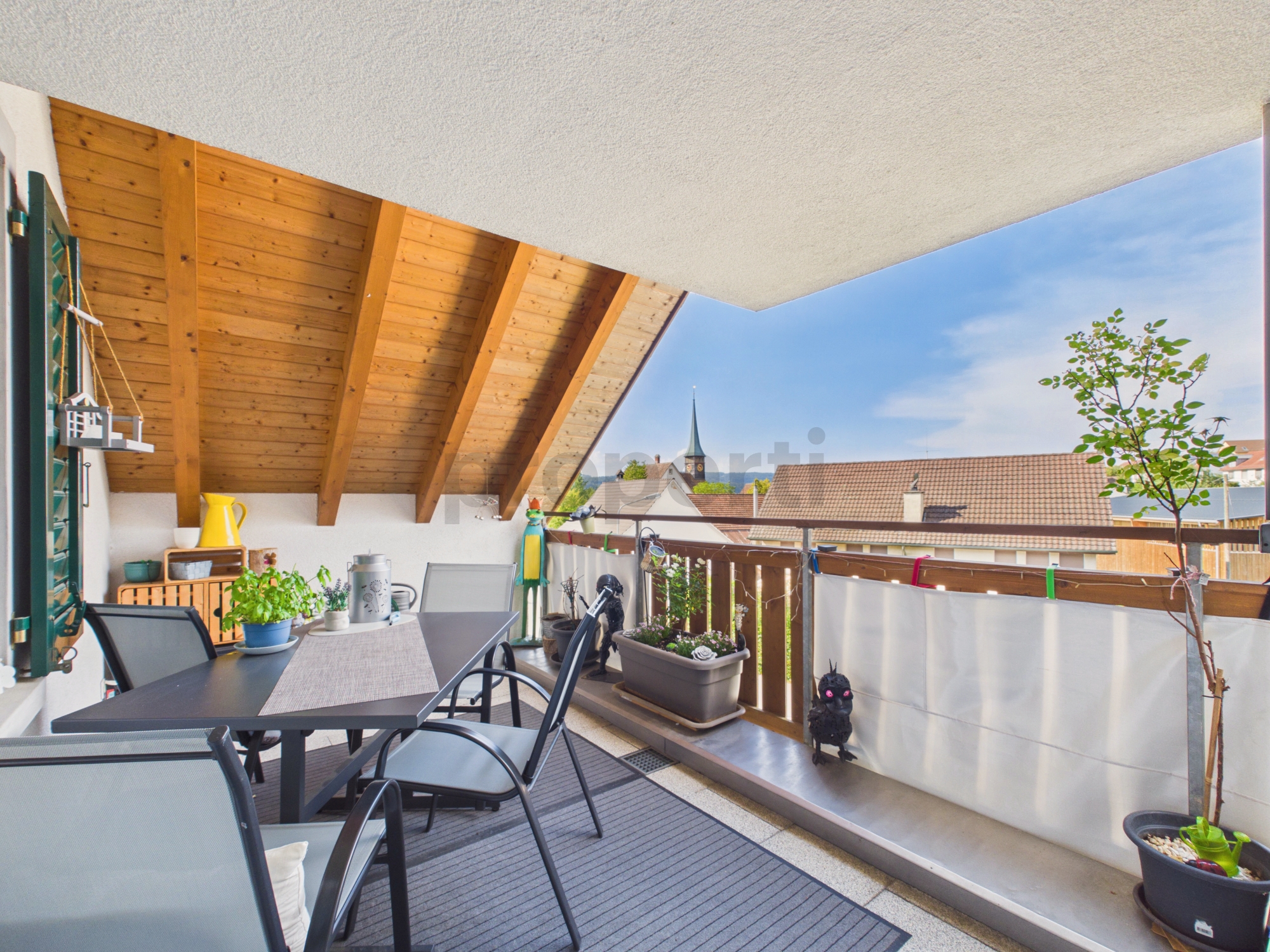 Überdachte Balkonterrasse mit Blick über die Dächer
