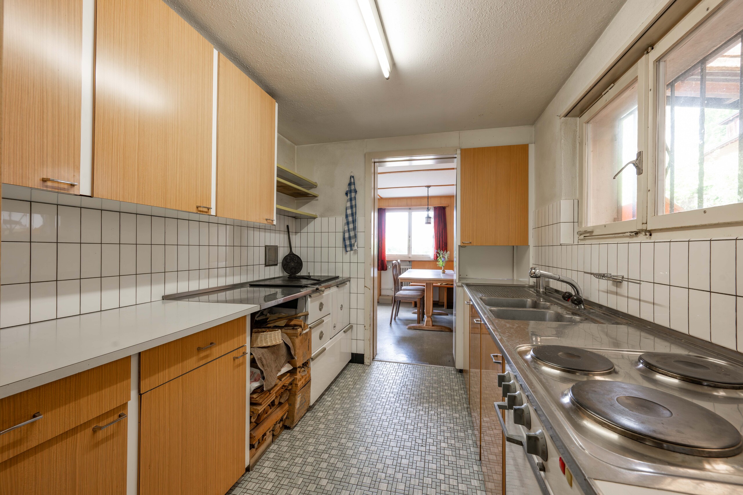 Schmale, ältere Küche mit Durchgang zum Essbereich