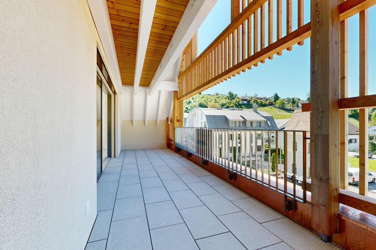 Überdachter Balkon mit Holzgeländer und Bergblick