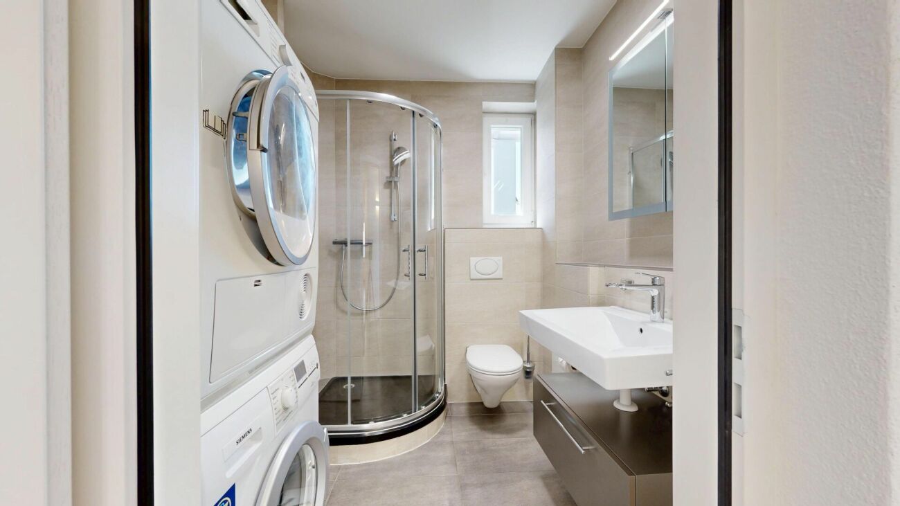 Modernes Badezimmer mit Dusche, Waschmaschine und WC