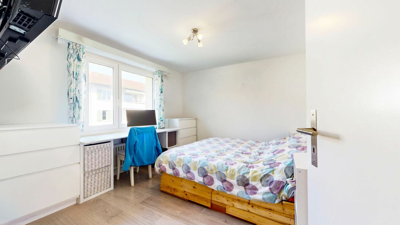 Helles Schlafzimmer mit Schreibtisch und Einzelbett